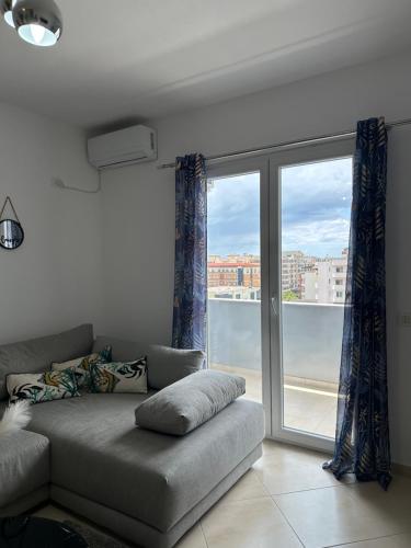 Sunset Apartment في دوريس: غرفة معيشة بها أريكة ونافذة كبيرة
