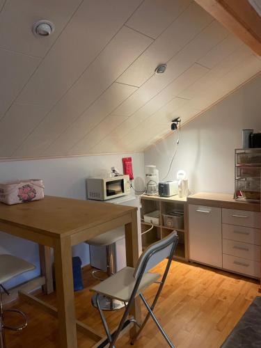 Una cocina con una mesa y sillas en una habitación. en Sweet home- room upstairs near skicenter Ounasvaara and golf course, en Rovaniemi
