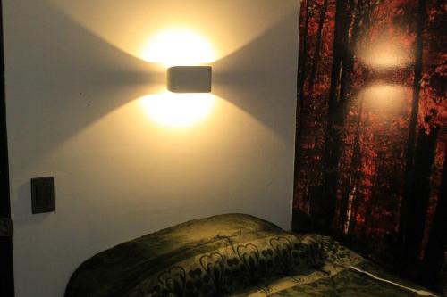 a bedroom with two lights on the wall at Regiotepec - Centro in Monterrey