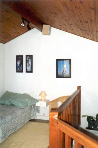 une chambre avec un lit et des tableaux au mur dans l'établissement Duplex en Hendaye, à Hendaye