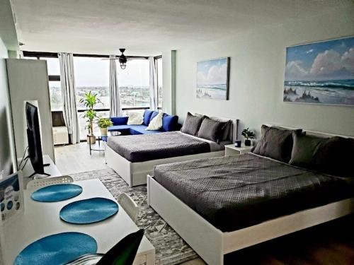 a living room with a bed and a couch at Daytona Ocean View Modern Studio in Daytona Beach