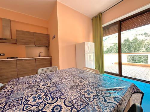 a kitchen with a table and a large window at Appartamento La Via Roma in Torre deʼ Passeri