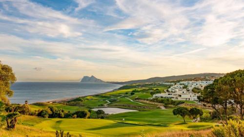 a golf course with a view of the ocean at Casa adosada cerca del centro y la playa in Alcaidesa