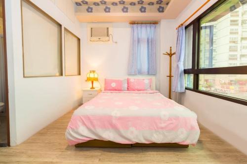 a bedroom with a pink bed and a window at 曉翠軒親子民宿 in Wujie