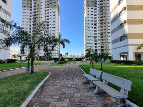 un parco con panchina, palme e edifici di Apto versátio trabalho e lazer a Cuiabá