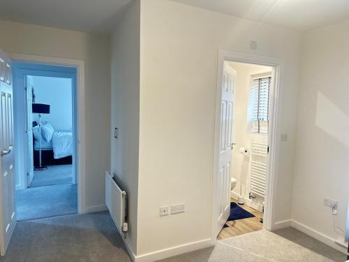 a room with white walls and a hallway with a bedroom at Luxury four bedroom house in Wolverhampton