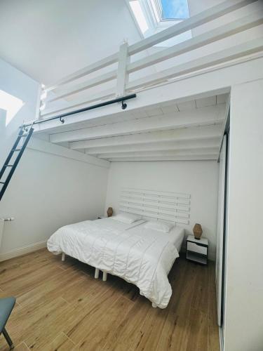 une chambre avec un grand lit blanc et une fenêtre dans l'établissement LOCATION MAISON LES PIEDS DANS L'EAU - 8 personnes, à Arcachon