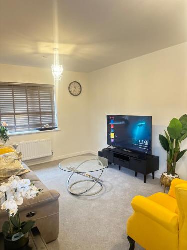 a living room with a flat screen tv and a couch at Luxury four bedroom house in Wolverhampton
