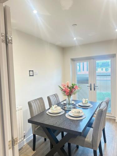 a dining room with a black table and chairs at Luxury four bedroom house in Wolverhampton