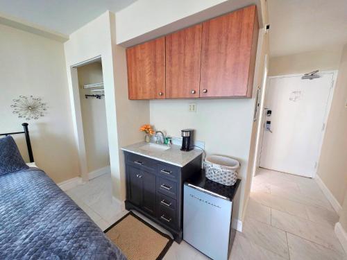a small kitchen with a sink and a counter at 2 queen bed studio w/kitchenette, pool, tiki bar in Daytona Beach