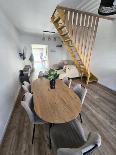 une salle à manger avec une table et des chaises en bois dans l'établissement Maison tout confort spacieuse, à Flers-en-Escrebieux