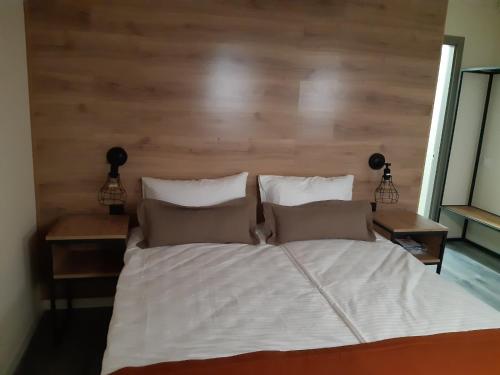 a bed with a wooden headboard and two night stands at Fishel in Odesa