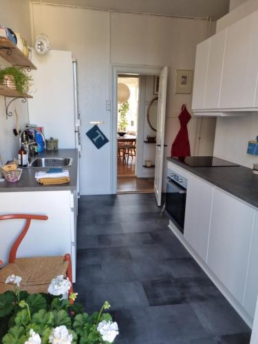 a kitchen with white cabinets and a black floor at Scandinavian city apartment in Aarhus