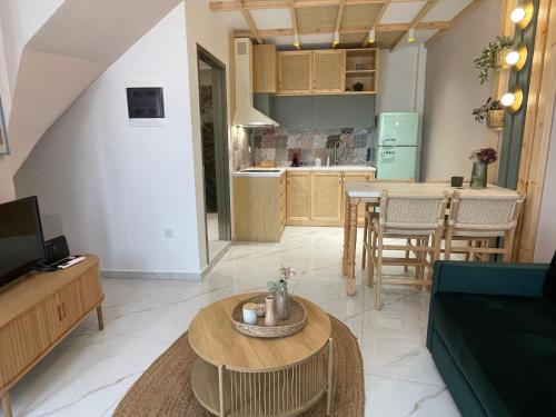 a living room with a table and a kitchen at Yataki Cozy House in Plomarion