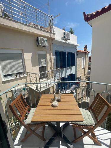 a wooden table and two chairs on a balcony at Yataki Cozy House in Plomarion
