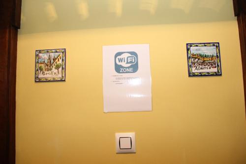 a wall with three pictures and a sign on it at Casa Mirador San Pedro in Arcos de la Frontera