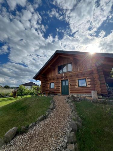 a log cabin with the sun shining on it at Holzhaus Wildsbergblick in Beiseförth