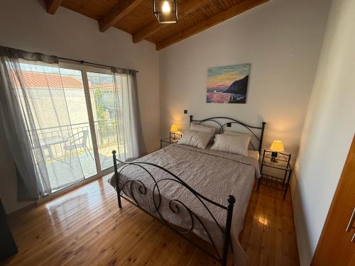 a bedroom with a bed and a large window at Prime Diakopto in Diakopto
