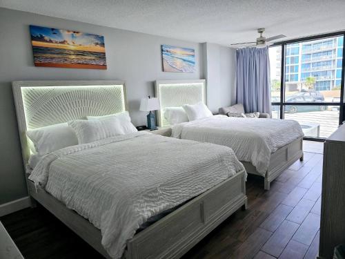 デイトナビーチにある3 Oceanview Studios connecting w/pool, tiki barのベッド2台と窓のある寝室