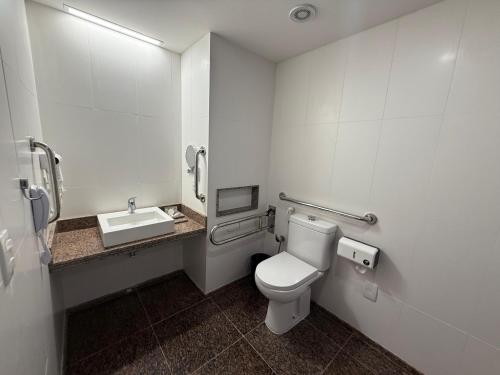 a bathroom with a toilet and a sink at HOTEL PIRÂMIDE NATAL in Natal