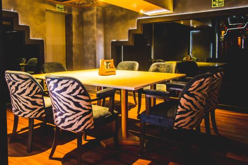 a dining room with a yellow table and chairs at Golden Parkk Hotel in Kolkata