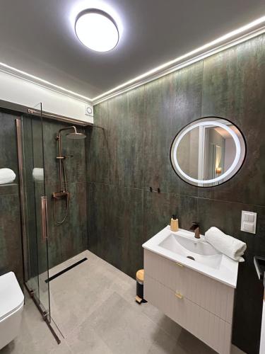 a bathroom with a shower and a sink and a mirror at siodemka in Darlowko