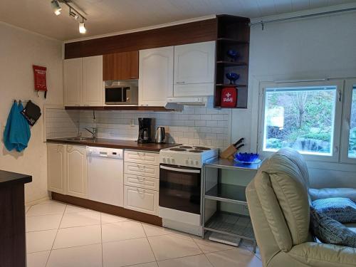una cucina con mobili bianchi e un forno a piano cottura di Villa Perttilä 