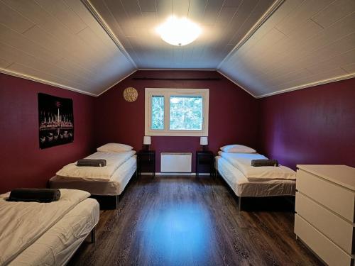 una stanza con tre letti e una finestra di Villa Perttilä 