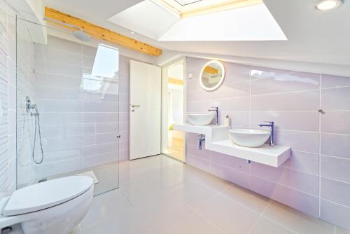 uma casa de banho branca com 2 lavatórios e um WC em Villa Demetra em Motovun