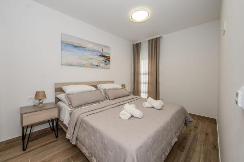 a bedroom with a bed with two towels on it at Apartmani Kornelija in Kaštela