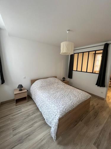 une chambre avec un lit et une grande fenêtre dans l'établissement L'appart des vignes, à Nuits-Saint-Georges