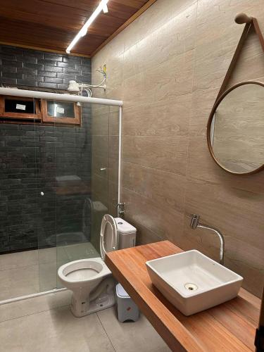 a bathroom with a toilet and a sink and a mirror at Chalé Iracema – Atins-MA in Atins