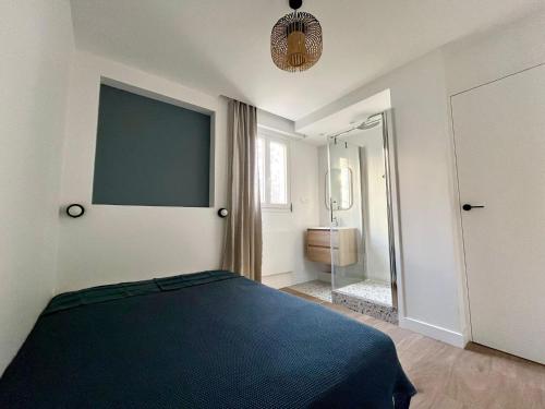 - une chambre avec un lit bleu et une salle de bains dans l'établissement Pauline, à Neuilly-sur-Seine