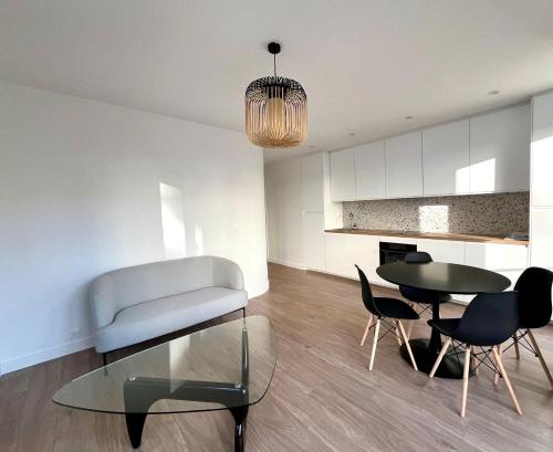 a living room with a couch and a table and chairs at Pauline in Neuilly-sur-Seine