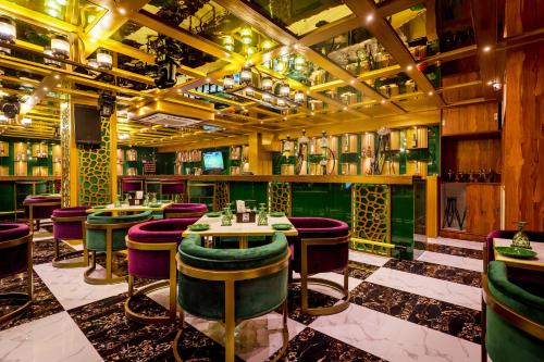 a bar with green and purple bar stools at Golden Parkk Hotel in Kolkata
