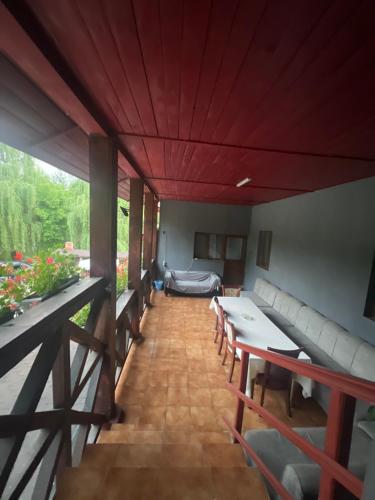 a living room with red ceilings and tables and chairs at Pensiunea Broscuta in Horezu