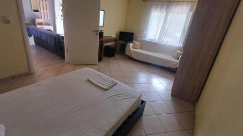 a room with a bed and a couch and a window at christos cottage! comfortable and quiet! in Keramotí