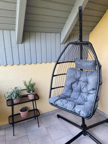 a swinging chair sitting on a porch with plants at Fränkisches Nest am Schwanberg für 2-4 Personen - in der Nähe aller Weingüter, KNAUF GIPS KG und ConneKT in Iphofen
