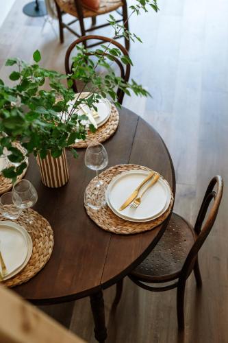 une table en bois avec des assiettes, des verres et des plantes dans l'établissement Wabi sabi lodge - spa&sauna privatif - forêt, à Turenne