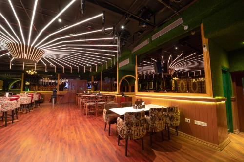 a restaurant with tables and chairs and a bar at Golden Parkk Hotel in Kolkata
