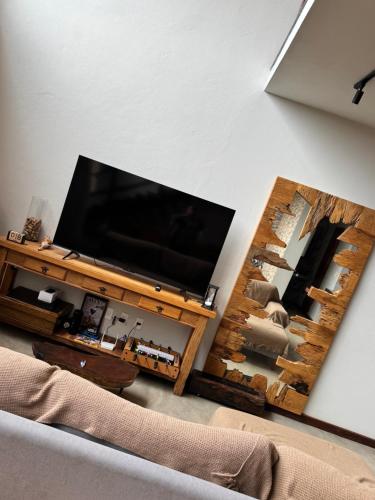 a living room with a flat screen tv on a table at Chalé Alto do Valle in Paty do Alferes