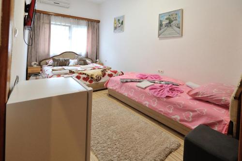 a room with two beds and a table at Motel Edem in Mostar