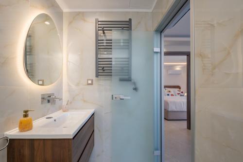 a bathroom with a sink and a shower with a mirror at Diamante Del Mar Thalia and Erato in Kos