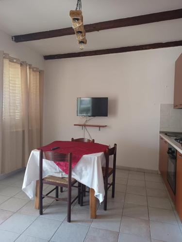 a kitchen with a table with a red table cloth on it at Astra Solea in Capo Vaticano