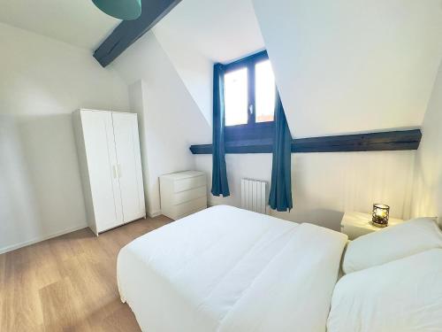 une chambre avec un lit blanc et une fenêtre dans l'établissement Cosy appart- 6 pers Netflix Hyper centre Douai, à Douai