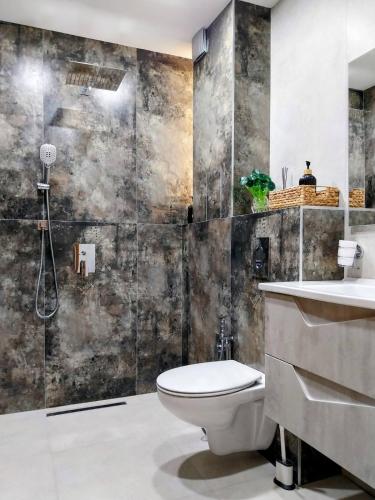 a bathroom with a toilet and a sink at Ika Delux in Burgas