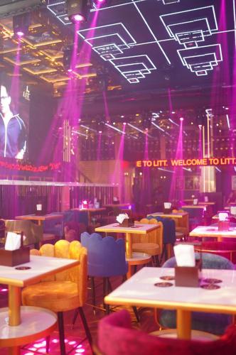 a room with tables and chairs and purple lights at Golden Parkk Hotel in Kolkata