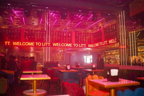 a restaurant with people sitting at tables and purple lights at Golden Parkk Hotel in Kolkata