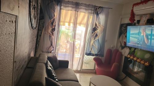 un salon avec un canapé et une télévision dans l'établissement Logement avec jacuzzi à 10 minutes à pied du port et des plages, à Bandol