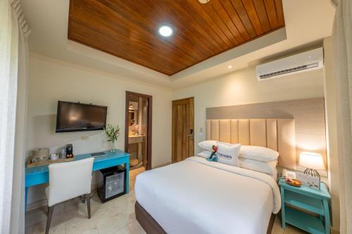 a bedroom with a bed and a desk and a television at Hotel Faranda Guayacanes, a member of Radisson Individuals in Chitré